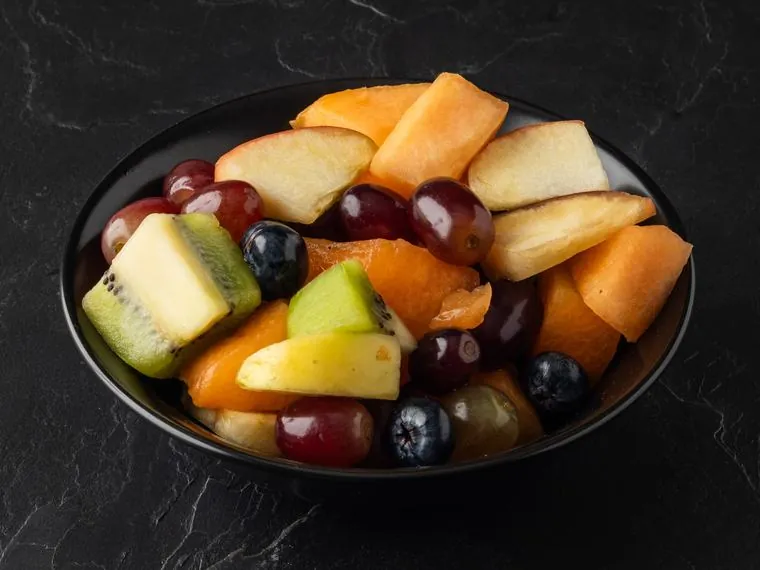 Vers fruit in een schaaltje: meloen, druiven, kiwi en appel